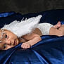 angel_wings, baby, blanket, blue_satin, costume, cute, diaper, expression, face, feet, hand, headband, infant, lying_down, newborn, portrait, skin, sleeping_area, soft_lighting, studio