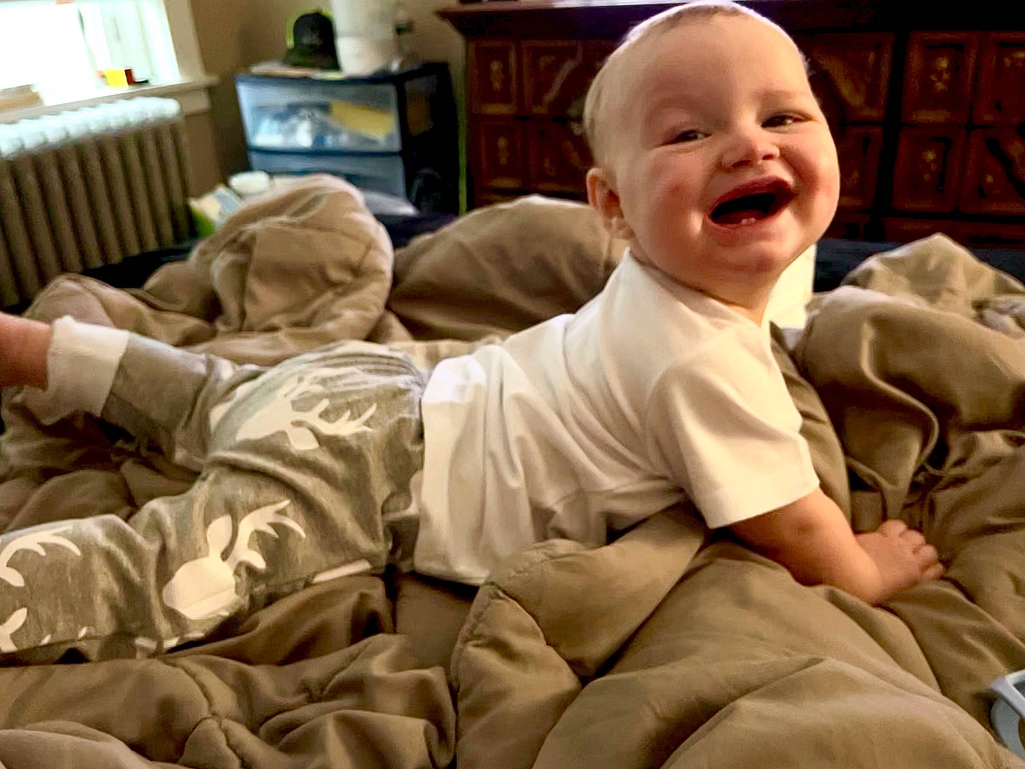 Kaleb is registered to the contest to win money with this photo: baby, baby_laughing, baby_toddler_clothing, cheek, child, comfort, fun, happy, houseplant, joy, knee, laugh, mouth, person, play, room, sitting, skin, sleeve, smile