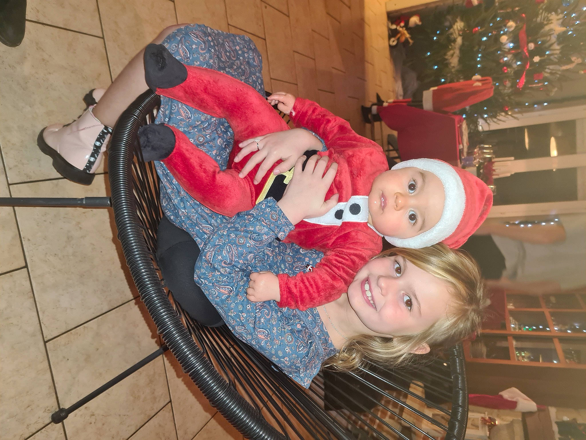 Ilyan participe au concours pour gagner de l'argent avec cette photo : carmine, child, christmas, christmas_decoration, christmas_eve, christmas_ornament, christmas_tree, event, flooring, foot, fun, happy, headwear, holiday, human_leg, joy, ornament, pattern, person, room