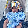 Terrell is registered to the contest to win money with this photo: baby, stroller, blanket, towel, milk_bottle, infant, child, seat, clothing, person, baby_bottle, blue, striped, cute, outdoor, foot, hand, expression, texture, warning_label