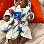 baby, child, robe, plush, bed, pillow, orange, white, blue, foot, hand, face, clothing, indoor, cute, infant, soft, blanket, person, relaxing