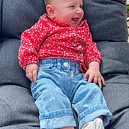 Amélia participe au concours pour gagner de l'argent avec cette photo : baby, child, smiling, jeans, red_clothing, socks, cushion, chair, happy, cute, portrait, indoors, infant, casual_clothing, relaxed, seated, baby_girl, denim, buttoned_shirt, cozy