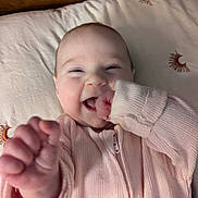 Daphne is registered to the contest to win money with this photo: baby, infant, smiling, happy, hand, clothing, pink, bed, bedding, moon, sun, pattern, face, cute, child, portrait, young, lying_down, soft, cozy
