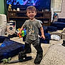 Ronald joined the competition — help win amazing prizes! toddler, child, boots, toy, living_room, television, smile, carpet, furniture, cushion, diapers, window, curtain, shirt, shorts, indoor, person, decor, plastic_toy, happy