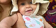 Valentina is registered to the contest to win money with this photo: baby, child, woman, hat, smile, indoor, portrait, holding, colorful, painting, art, arm, clothing, face, expression, person, wall, background, cute, happy