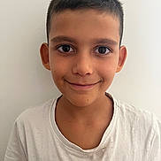 Lorenzo participe au concours pour gagner de l'argent avec cette photo : child, boy, smile, short_hair, white_tshirt, portrait, face, young, casual_clothing, indoors, neutral_background, person, head_and_shoulders, friendly, looking_at_camera, human, skin, eyebrows, ears, expression
