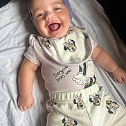 Jessalynn joined the competition — help win amazing prizes! baby, bed, bib, blanket, bow, cartoon, child, close_up, clothing, face, happy, headwrap, indoor, infant, lying_down, minnie_mouse, outfit, portrait, short_sleeves, smiling