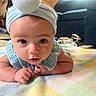 Jessalynn is registered to the contest to win money with this photo: arms, baby, bib, blue_clothing, bow_headband, carpet, child, close_up, hands, home, indoor, infant, living_room, looking_at_camera, lying_down, pastel_blanket, portrait, quilt, sofa, wide_eyes