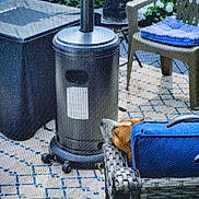 Buster is registered to the contest to win money with this photo: backyard, beige, blue, chair, cushion, dog, flowers, garden, heater, home, metal, outdoor, patio, pet, plants, relaxing, screen, shade, wicker_furniture, woven