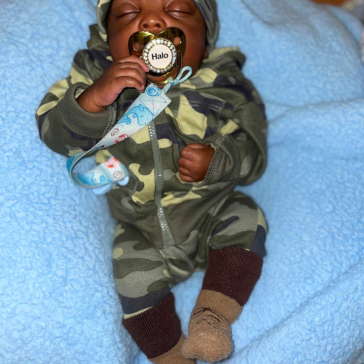 Halo is registered to the contest to win money with this photo: baby, blanket, bodypart, cap, clothing, coat, couch, face, finger, furniture, hand, hat, head, hosiery, jacket, person, photography, portrait, sock, toy