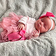 Elena participe au concours pour gagner de l'argent avec cette photo : baby, sleeping, pink_skirt, headband, blanket, soft_texture, infant, peaceful, cute, child, newborn, clothing, hand, face, resting, indoor, toddler, portrait, cozy, fabric