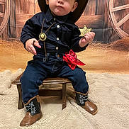 Ezechiel a rejoint le concours — aidez-le/la à gagner de superbes lots ! child, toddler, cowboy_costume, cowboy_hat, sheriff_badge, red_bandana, cowboy_boots, jeans, navy_shirt, wooden_stool, western_backdrop, wagon_wheel, hay, blanket, portrait, sitting, indoor, adorable, cute_expression, photoshoot