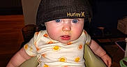 Winter is registered to the contest to win money with this photo: baby, baby_seat, blue_eyes, child, chubby_cheeks, clothing, curious, cute, expression, face, furniture, hat, home, indoor, infant, light, onesie, person, seat_belt, sun_pattern
