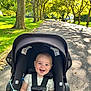 Caden joined the competition — help win amazing prizes! baby, smile, stroller, child, outdoor, sunlight, trees, path, park, greenery, happy, infant, seatbelt, nature, daylight, toddler, leaves, shade, walk, person