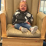 Mae joined the competition — help win amazing prizes! toddler, child, smiling, sitting, chair, wooden_chair, hoodie, jeans, pink_bow, indoor, happy, footwear, sneakers, person, cute, young_child, casual_clothing, furniture, portrait, playful