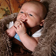 Weston joined the competition — help win amazing prizes! baby, infant, child, portrait, face, eyes, hands, fingers, smiling, curious, lying_down, blanket, fluffy, brown, clothing, indoor, cozy, close_up, photography, safe