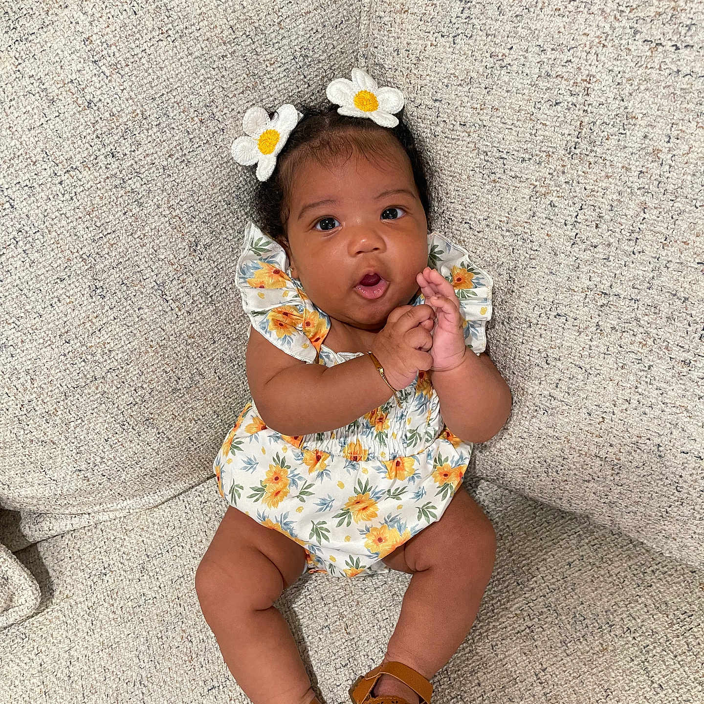 Oaklynn joined the competition — help win amazing prizes! baby, child, clapping, comfortable, couch, cute, expression, floral_dress, flower_hairclip, footwear, girl, hand, happy, indoors, person, portrait, sandals, sitting, skin, texture
