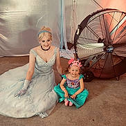 Aubrey is registered to the contest to win money with this photo: child, woman, princess_costume, dress, crown, smile, indoor, fan, carpet, gloves, headband, happy, seated, floor, portrait, costume, event, light, fabric, person