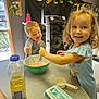 Aubrey joined the competition — help win amazing prizes! child, children, kitchen, baking, whisk, mixing_bowl, smiling, happy, cooking, apron, table, food, indoor, person, young, curly_hair, blond_hair, egg_carton, bottle, playful