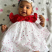 Anvi is registered to the contest to win money with this photo: baby, child, infant, dress, red, white, polka_dots, headband, blanket, stars, lying_down, cute, portrait, indoors, soft_texture, happy, smiling, young, hands, legs