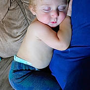 Hyland is registered to the contest to win money with this photo: toddler, sleeping, couch, blue_pillow, bare_chest, curled_up, child, nap, cozy, blond_hair, soft_skin, relaxed, indoor, home, comfort, peaceful, cute, young_child, pajamas, feet