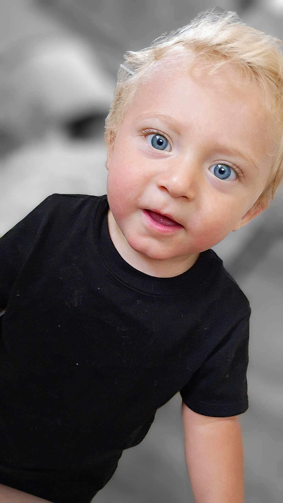 Hyland Rush is registered to the contest to win money with this photo: baby, black_tshirt, blonde_hair, blue_eyes, casual_clothing, child, closeup, curious, cute, expression, face, head_and_shoulders, human, indoors, innocent, person, portrait, skin, toddler, young_child