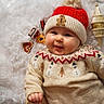 Ella participe au concours pour gagner de l'argent avec cette photo : baby, infant, smile, red_hat, knit_hat, gingerbread_man, festive_sweater, snowman_pattern, cozy, fluffy_background, holiday_decor, cute, portrait, child, winter_clothing, cheerful, warm, indoor, happy, holiday