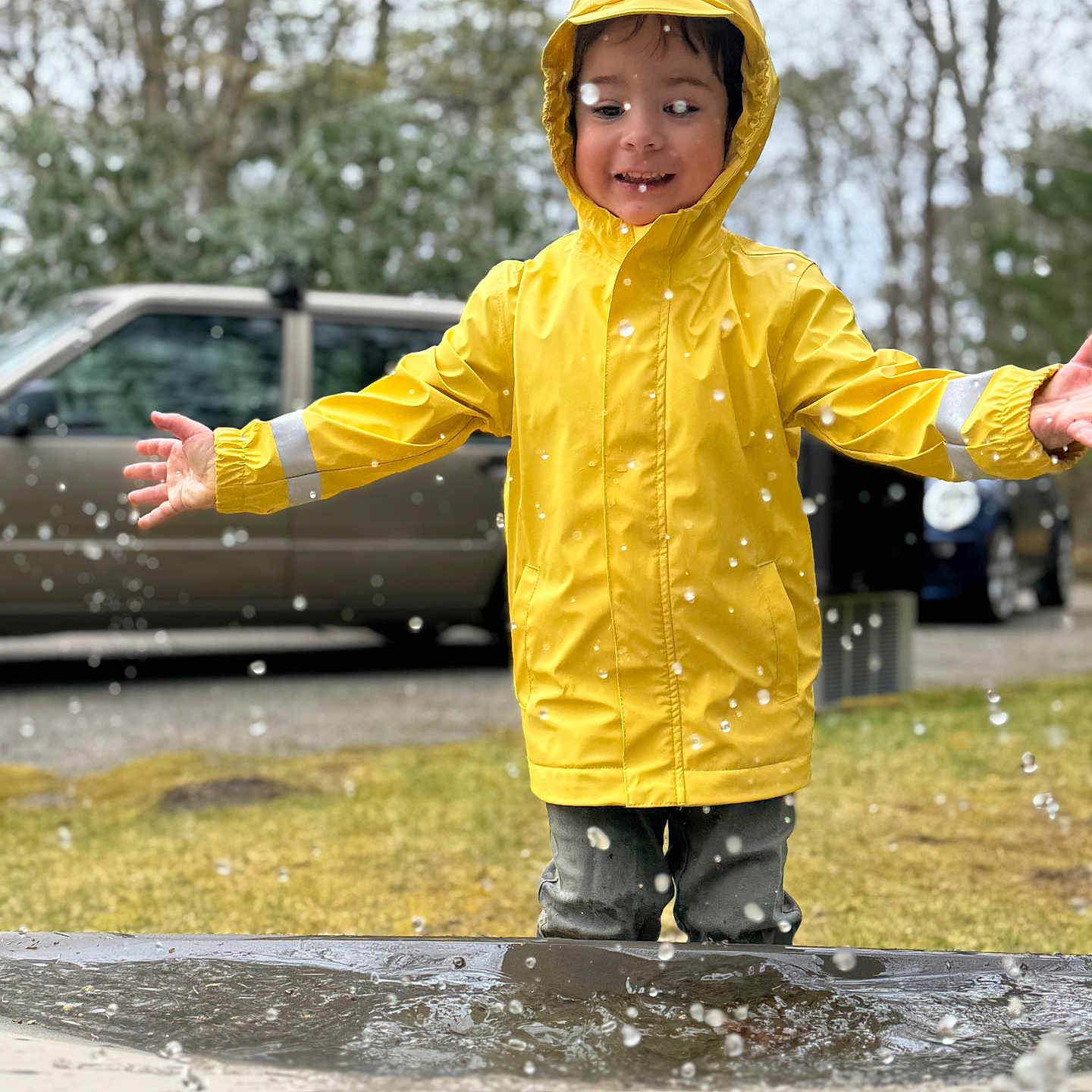 Baxter joined the competition — help win amazing prizes! boy, car, child, clothing, coat, face, head, jacket, male, person, photography, portrait, puddle, raincoat, transportation, vehicle, water