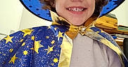 Ethan a rejoint le concours — aidez-le/la à gagner de superbes lots ! child, wizard_costume, hat, cape, stars, blue, gold, smile, indoor, person, face, curly_hair, clothing, magic, happy, portrait, costume, young, fun, fantasy