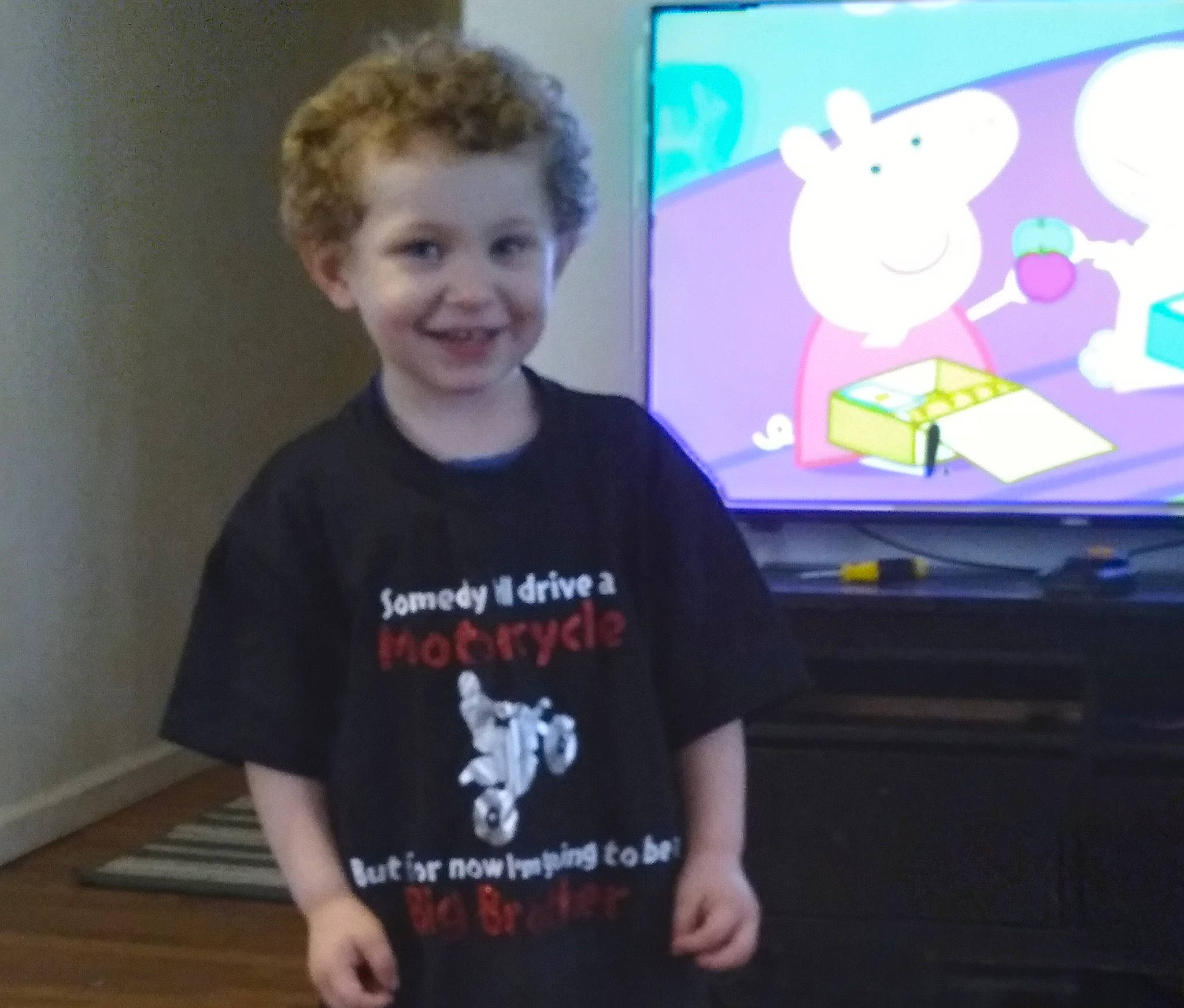 Braxton is registered to the contest to win money with this photo: active_shirt, art, child, display_device, event, finger, fun, gadget, happy, joy, laugh, mammal, person, room, sitting, sleeve, smile, t_shirt, television_set, toddler