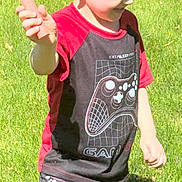 Niklaus is registered to the contest to win money with this photo: child, boy, outdoor, grass, sunlight, smiling, short_hair, tshirt, shorts, gaming_theme, carrot, playful, nature, casual_clothing, summer, happy, person, standing, daylight, fun