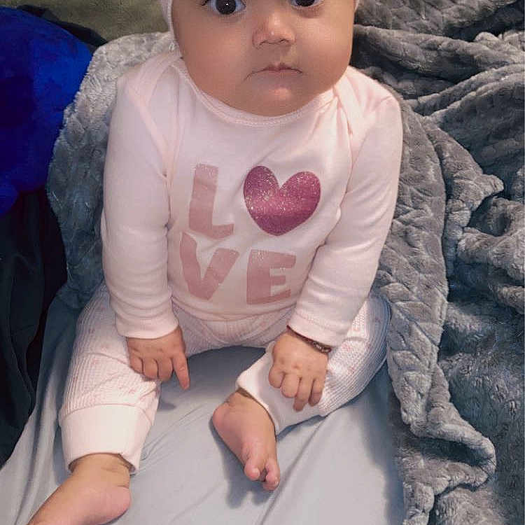 Isela joined the competition — help win amazing prizes! baby, baby_toddler_clothing, cap, cheek, comfort, costume_hat, eye, face, finger, gesture, head, human_body, iris, lip, nose, outerwear, purple, skin, sleeve, toddler