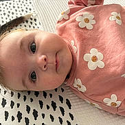 Héléna participe au concours pour gagner de l'argent avec cette photo : baby, infant, child, face, pink_clothing, floral_pattern, blanket, patterned_blanket, eyes, cute, lying_down, young_child, soft_texture, indoors, portrait, closeup, skin, head, expression, adorable