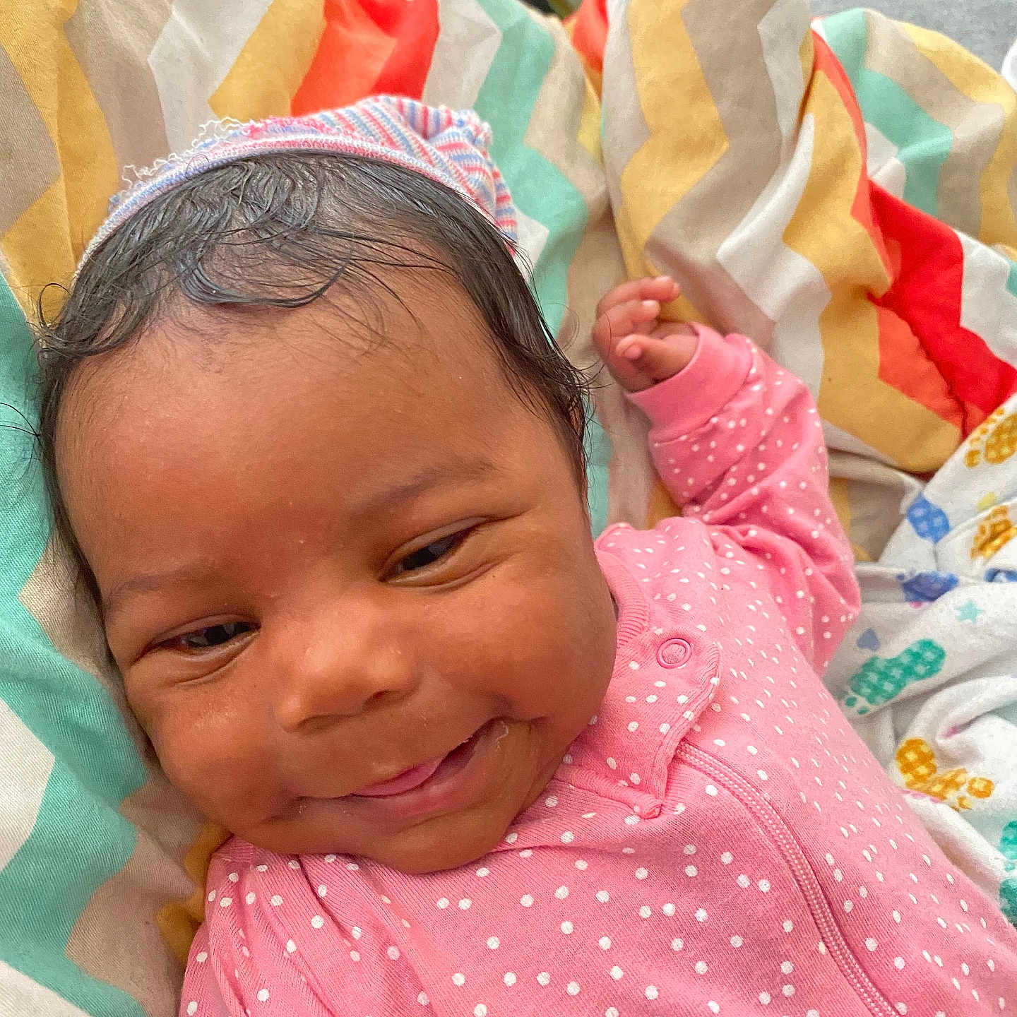 Lamauri Coleman joined the competition — help win amazing prizes! baby, blanket, child, colorful, comfort, cozy, cute, face, happy, indoors, infant, lying_down, newborn, pink_onesie, polka_dot, portrait, skin, smiling, soft, striped_cap