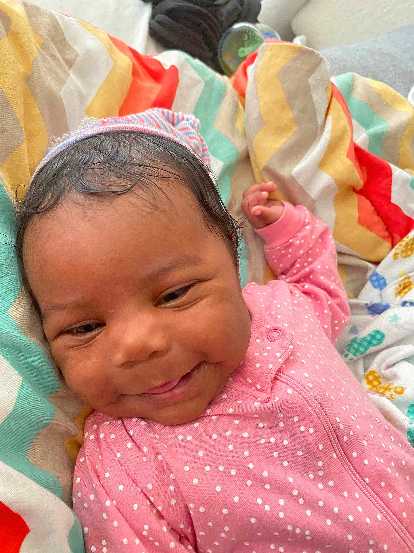 Lamauri Coleman joined the competition — help win amazing prizes! baby, blanket, child, colorful, comfort, cozy, cute, face, happy, indoors, infant, lying_down, newborn, pink_onesie, polka_dot, portrait, skin, smiling, soft, striped_cap