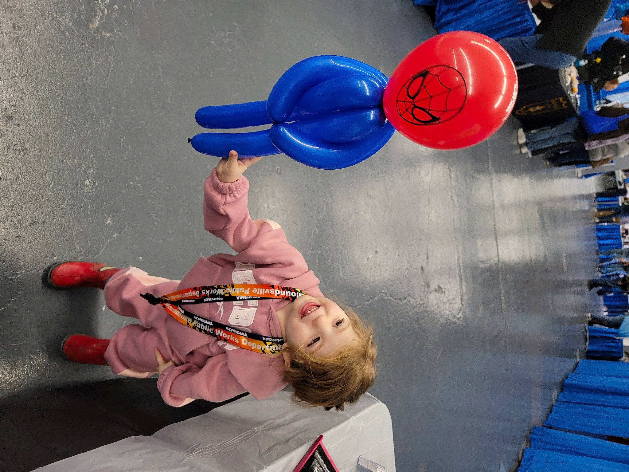 Olivia is registered to the contest to win money with this photo: balance, balloon, blue, child, elbow, electric_blue, fun, gesture, happy, human_leg, joy, leisure, party_supply, performing_arts, person, physical_fitness, play, recreation, sitting, snapshot