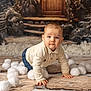 baby, background, blue_eyes, blurred_background, child, cozy, crawling, cream_sweater, face, festive, hands, indoor, jeans, portrait, props, short_hair, snowballs, stone_floor, winter, wooden_door