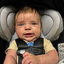 baby, car_seat, infant, child, safety_harness, blanket, cute, smiling, clothing, person, seat, head_support, indoors, closeup, expression, skin, hand, face, young, comfort