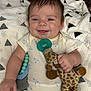 Hudson is registered to the contest to win money with this photo: baby, smiling, infant, plush_toy, giraffe, pacifier, beaded_clip, blanket, white_blanket, patterned_blanket, clothing, onesie, happy, cute, child, portrait, indoors, lying_down, soft_toy, baby_toy