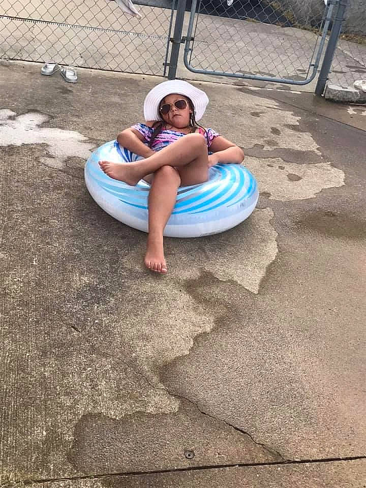 Kinsey is registered to the contest to win money with this photo: asphalt, automotive_tire, barefoot, city, concrete, electric_blue, flooring, foot, fun, grass, hat, headwear, human_leg, leisure, person, recreation, road, road_surface, shorts, sidewalk