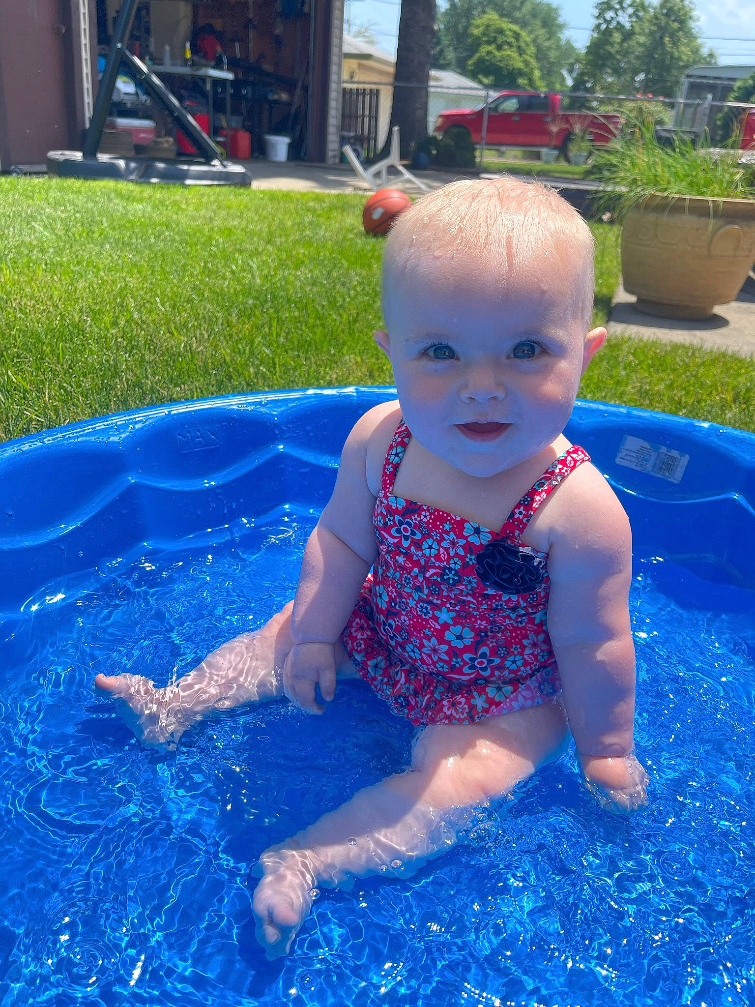 Averie is registered to the contest to win money with this photo: azure, baby, baby_toddler_clothing, bathing, blue, electric_blue, flowerpot, fun, grass, happy, houseplant, leisure, people_in_nature, person, plant, recreation, smile, summer, swimming_pool, toddler