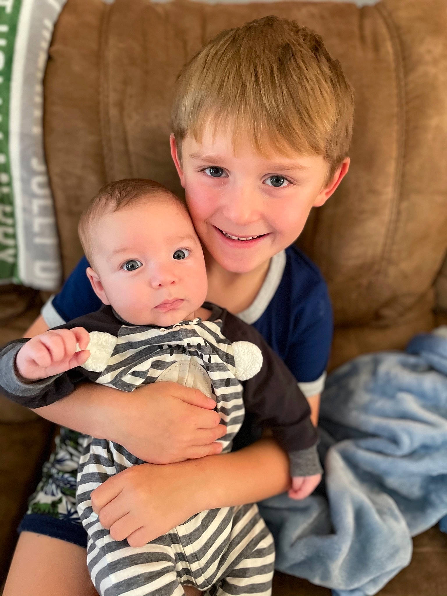 Maxwell is registered to the contest to win money with this photo: arm, baby_toddler_clothing, cheek, comfort, couch, eye, face, facial_expression, hairstyle, happy, head, human, human_body, iris, joy, mammal, organ, person, photograph, skin