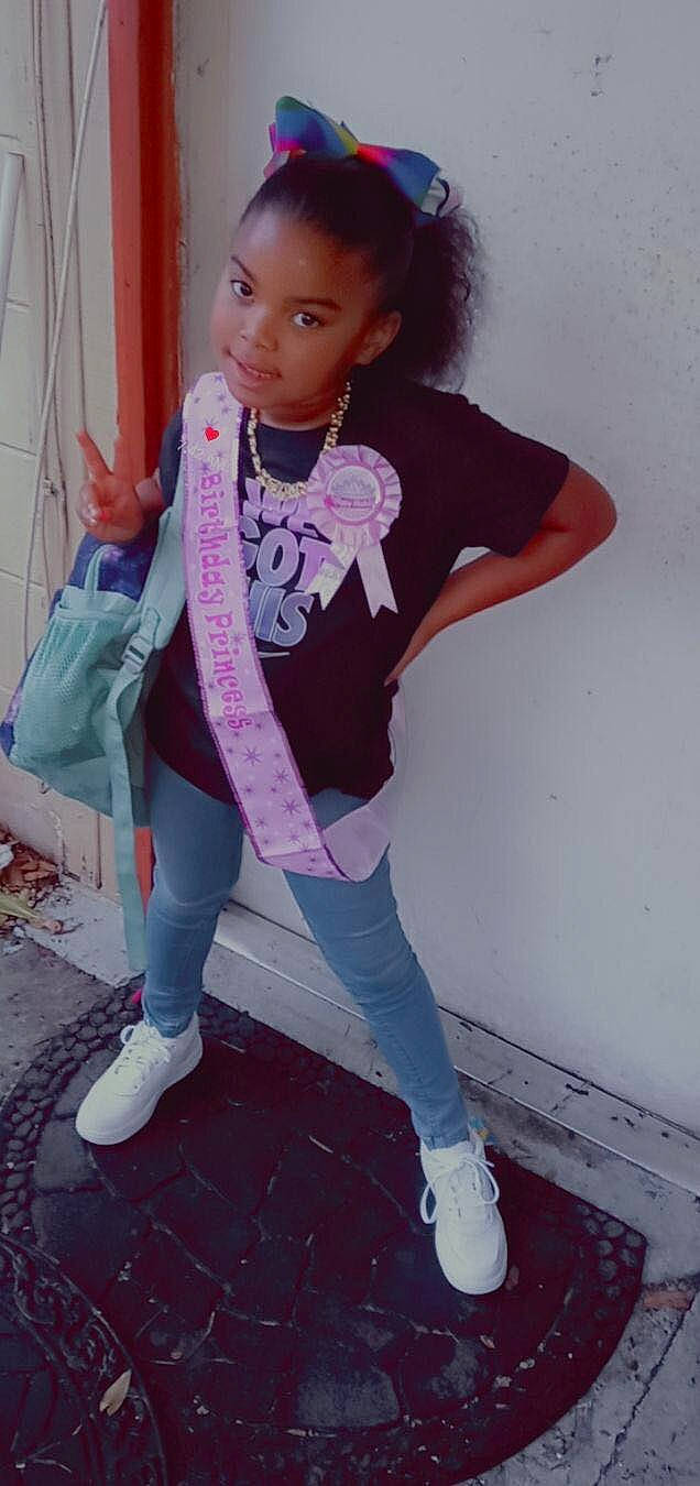 Kenyatta is registered to the contest to win money with this photo: cool, curtain, denim, footwear, hair, knee, leg, magenta, pattern, person, pink, purple, shoe, sleeve, sneakers, sock, street_fashion, t_shirt, thigh, toddler