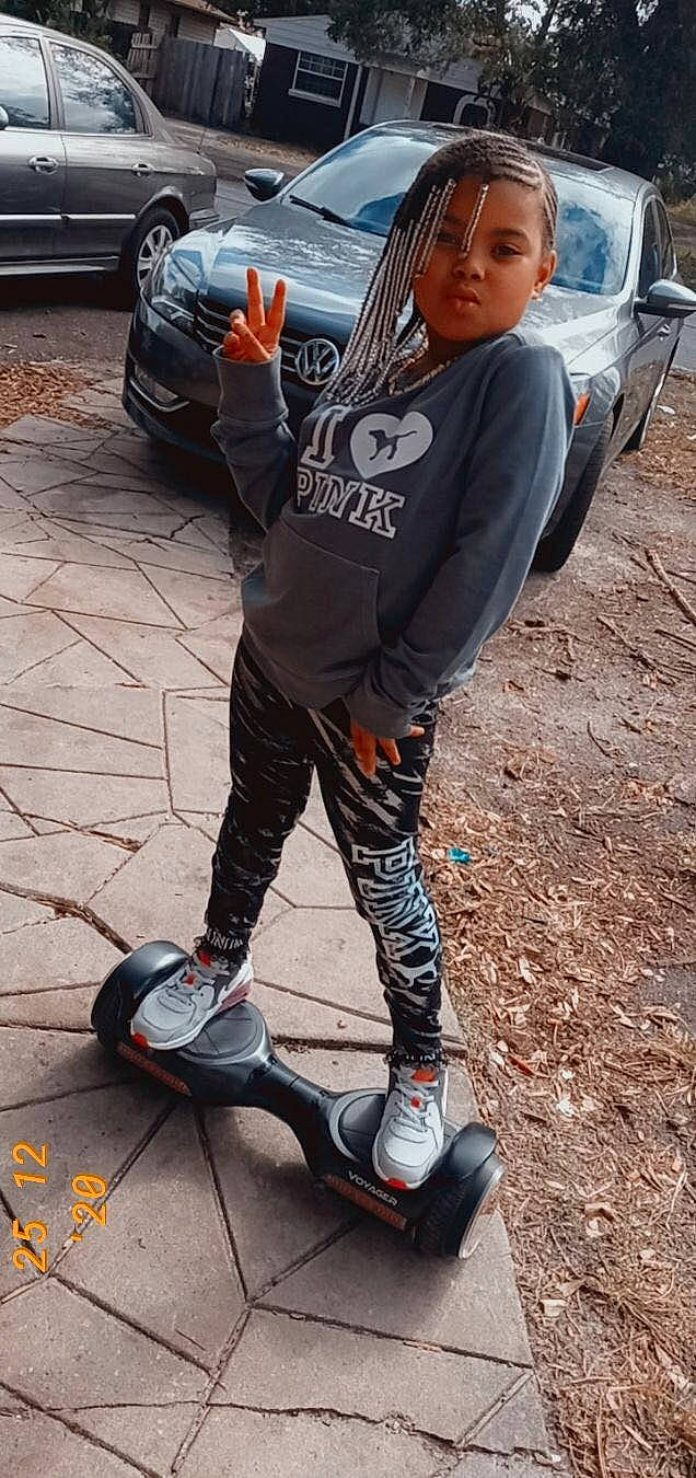 Kenyatta is registered to the contest to win money with this photo: asphalt, car, cool, eyewear, human_leg, knee, leg, person, personal_protective_equipment, recreation, road, rolling, shoe, sidewalk, sneakers, sports_equipment, sportswear, street_fashion, t_shirt, thigh