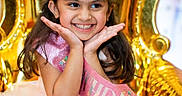 Ariza is registered to the contest to win money with this photo: child, girl, birthday, tiara, sash, dress, smile, happy, party, celebration, golden_throne, pink, tulle, cute, portrait, festive, young, hands_on_face, long_hair, indoor