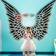 Ariza joined the competition — help win amazing prizes! child, girl, dress, pink, angel_wings, halo, smile, standing, indoor, bright_colors, floor, wall_art, portrait, happy, cute, toddler, playful, light, pose, costume