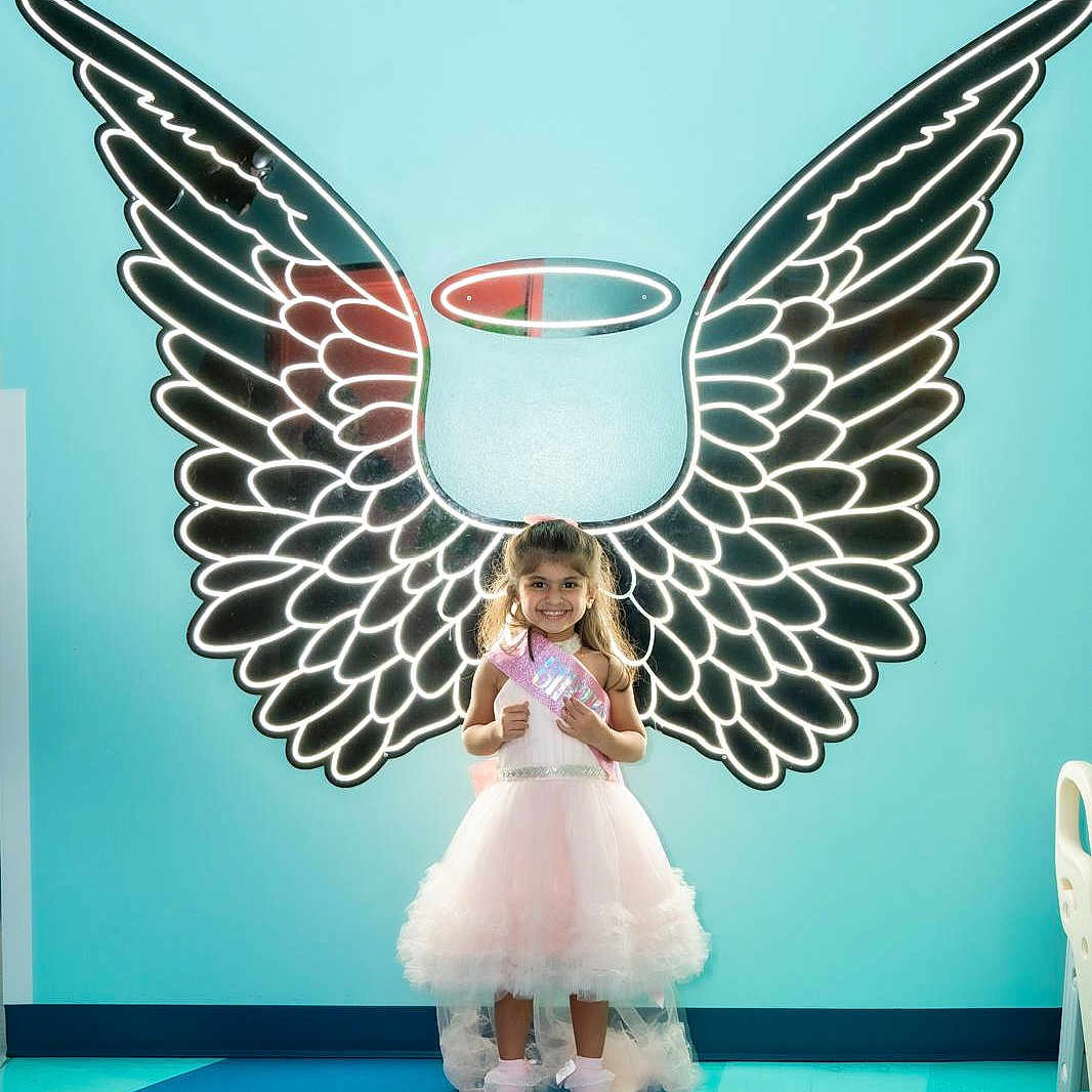 Ariza joined the competition — help win amazing prizes! child, girl, dress, pink, angel_wings, halo, smile, standing, indoor, bright_colors, floor, wall_art, portrait, happy, cute, toddler, playful, light, pose, costume