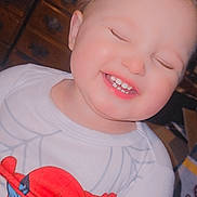 Kysen is registered to the contest to win money with this photo: baby, child, chubby_cheeks, closeup, clothing, cute, dresser, drool, face, happy, indoor, laughing, onesie, playful, portrait, smiling, spiderman, teeth, toddler, wooden_furniture