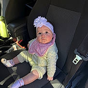 Areya is registered to the contest to win money with this photo: baby, infant, child, flower_headband, headband, pink_bib, knit_outfit, socks, car_seat, car_interior, seat_belt, buckle, portrait, looking_up, big_eyes, cute, sitting, sunlight, hand, seat