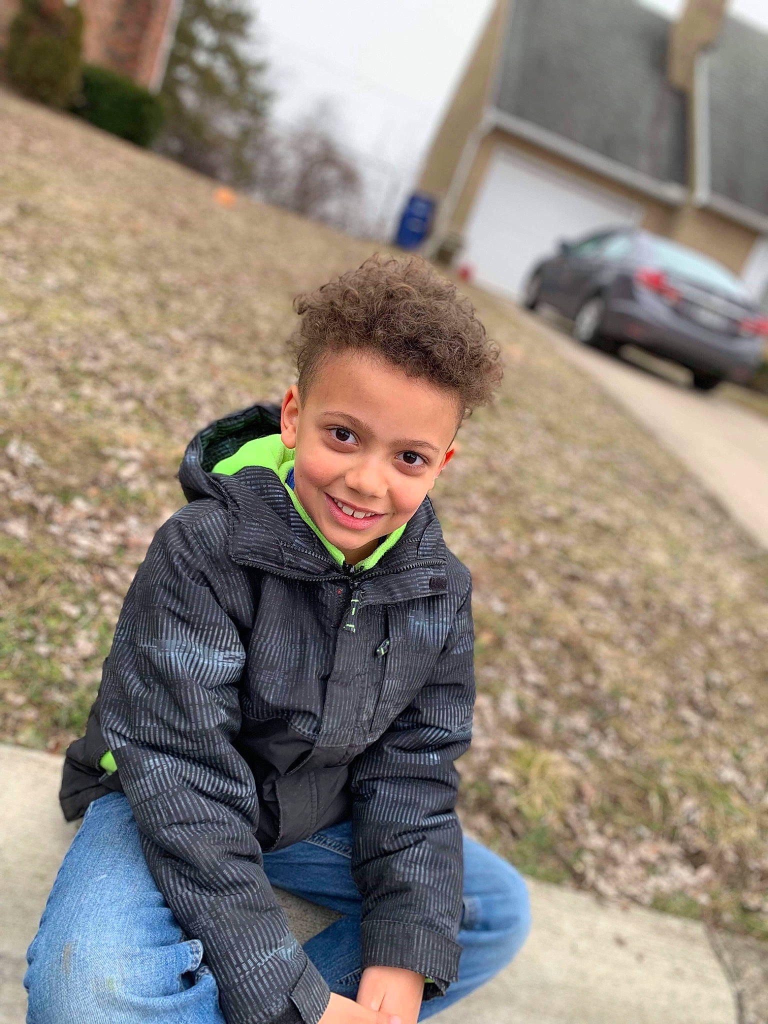 Dajuan is registered to the contest to win money with this photo: baby, child, face, fun, grass, hoodie, jacket, jeans, joy, male, outerwear, people, person, photography, play, recreation, sitting, smile, toddler, tree